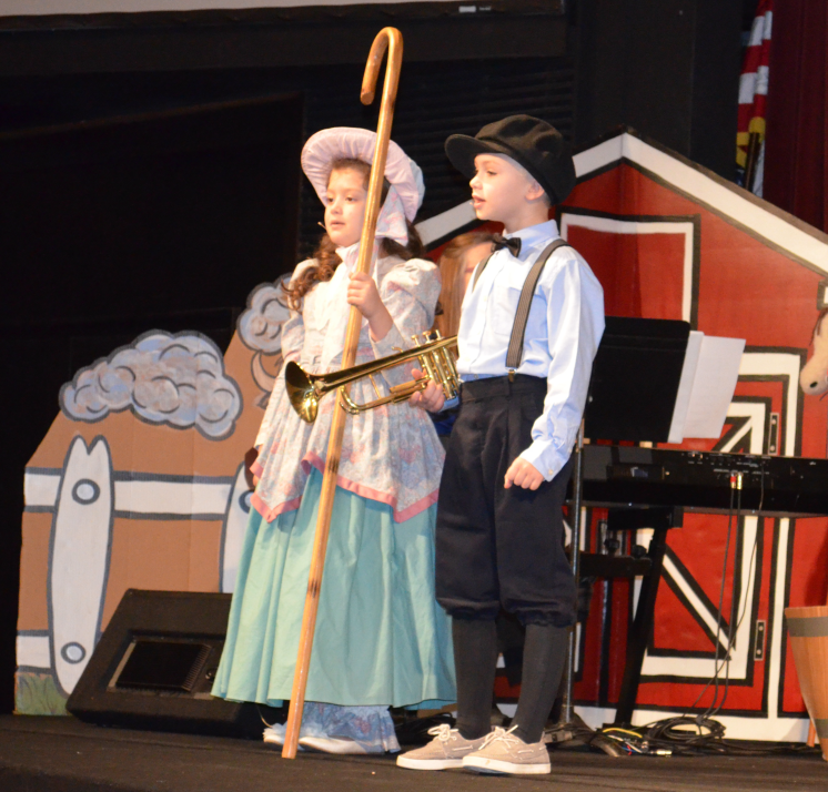 A young boy and a girl in costume participating in a play